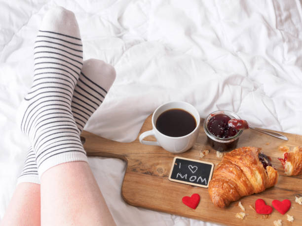 istock Woman with a breakfast tray on a white coverlet 1146005878