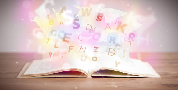 istock Open book with glowing letters on concrete background 1146007174