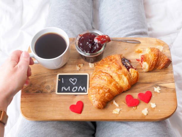 Woman with a breakfast on a serving tray on her lap