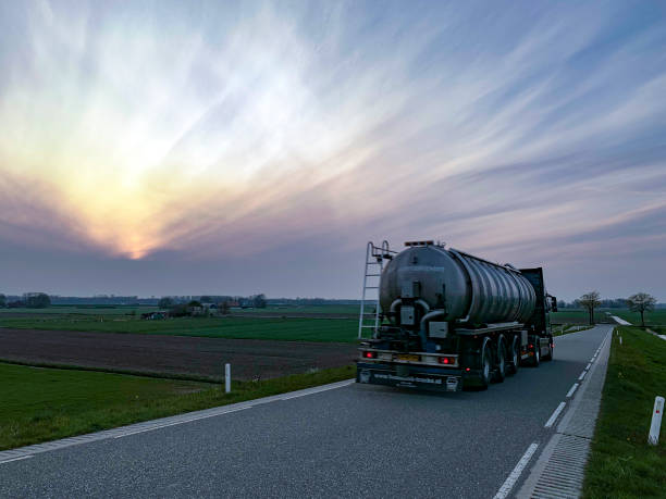 camion-citerne conduisant sur une route de campagne pendant le coucher du soleil - truck fuel tanker oil semi truck photos et images de collection
