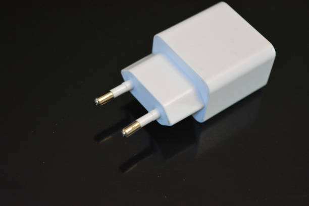 istock On a black glossy background, there is a white USB charge for 220 volts for the phone and a reflection. 1146011479