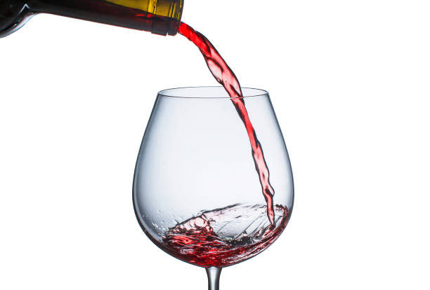 istock Pouring red wine in a glass with splashes 1146016056