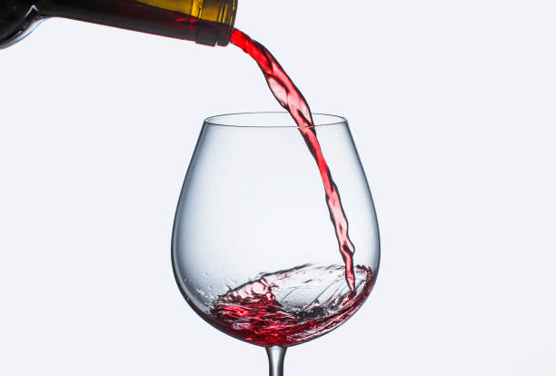 istock Pouring red wine in a glass with splashes 1146016067