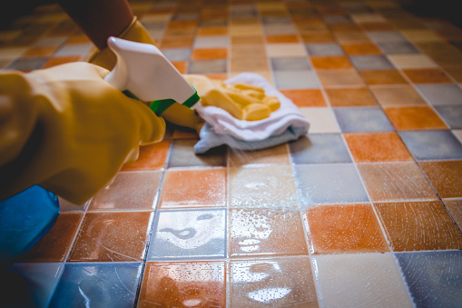 Close-up woman cleaning tiled