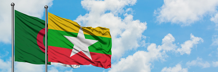 Algeria and Myanmar flag waving in the wind against white cloudy blue sky together. Diplomacy concept, international relations.