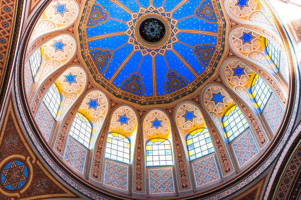 Ornate interior Architecture and dome of Jewish Synagogue Wide angle color image depicting the ornate decorative architecture inside a Jewish synagogue. The dome and stained glass windows are adorned with an elaborate pattern using the star of David symbol. Room for copy space. synagogue photos stock pictures, royalty-free photos & images