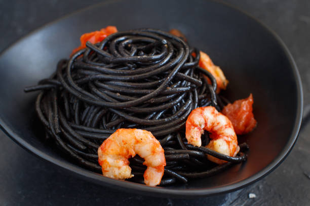 istock Squid ink pasta with prawns and tomatoes 1146020479