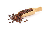 Wooden scoop of roasted coffee beans on white