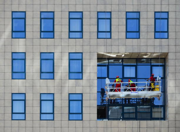 Window cleaners working on building standing on the scaffolding