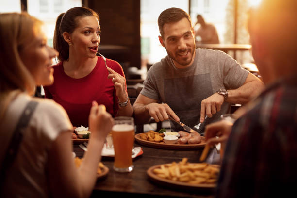 grupo de amigos felizes que têm um almoço em uma taberna. - pub food - fotografias e filmes do acervo