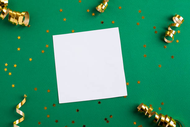 istock White paper sheet, golden decorations and sparkles on green background 1146029842