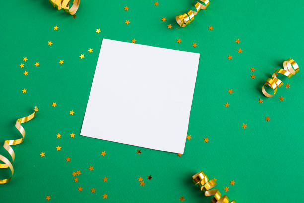 istock White paper sheet, golden decorations and sparkles on green background 1146029864
