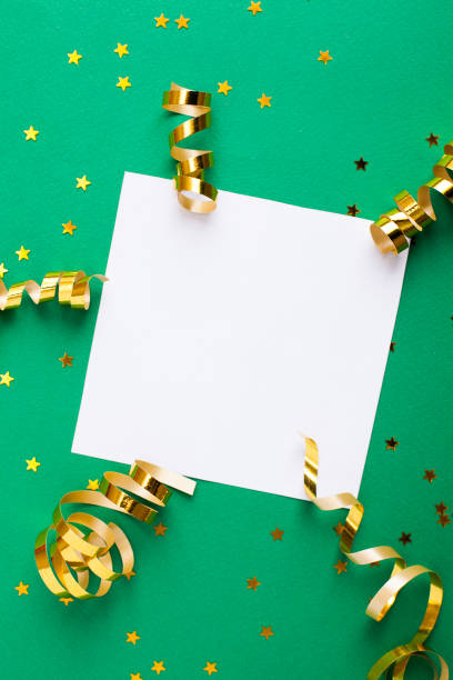 istock White paper sheet, golden decorations and sparkles on green background 1146029883