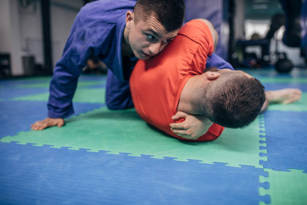 istock Two men wrestling on the floor in gym 1146030162