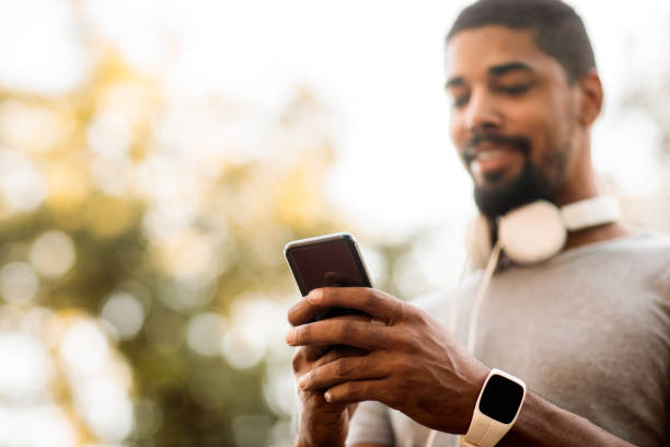 istock Young male using online chat on a mobile phone in a park 1146032024