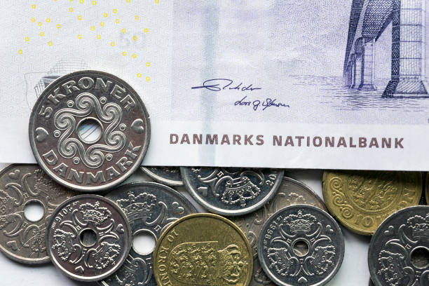 A fifty kroner note with a selection of mixed Danish coins. The krone is the official currency of Denmark, Greenland, and the Faroe Islands, introduced on 1 January 1875.