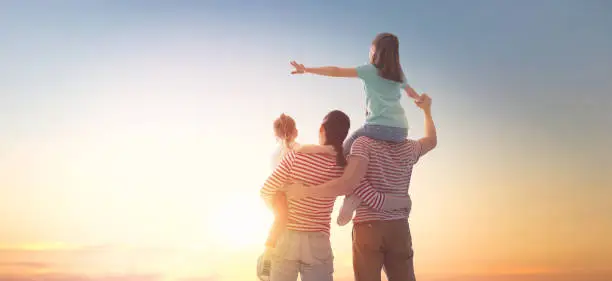 Photo of happy family at sunset.