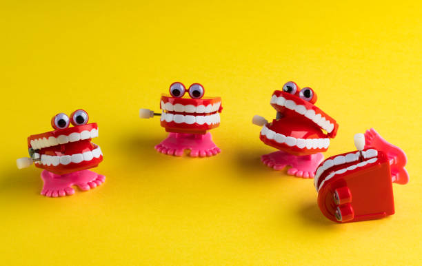 Four Clockwork Mouths Laughing One Fell Over on Yellow Background