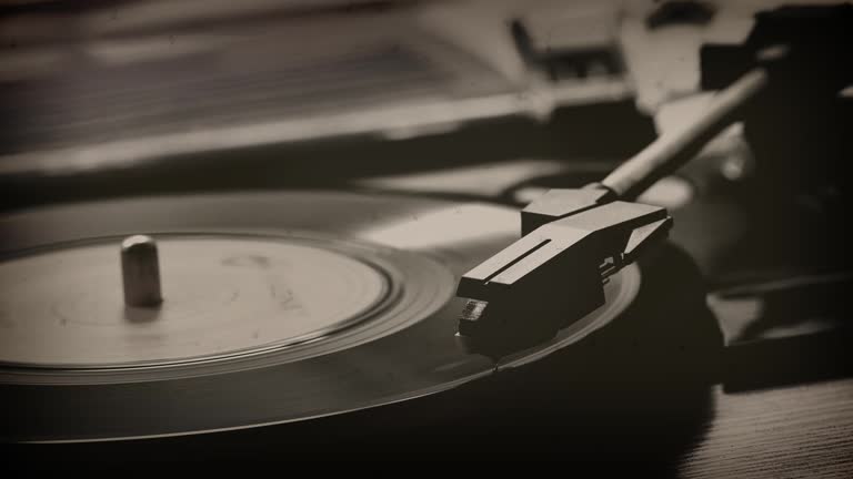 45rpm single record on a turntable. Monochrome.