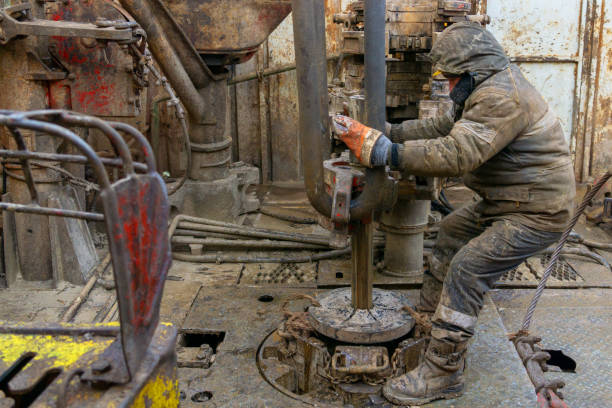 Offshore oil rig worker prepare tool and equipment for perforation oil and gas well at wellhead platform. Making up a drill pipe connection. A view for drill pipe connection from between the stands. Offshore oil rig worker prepare tool and equipment for perforation oil and gas well at wellhead platform. Making up a drill pipe connection. A view for drill pipe connection from between the stands wellhead stock pictures, royalty-free photos & images