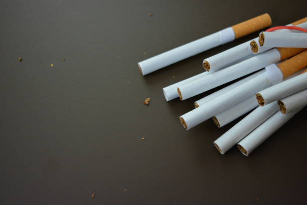 New decomposed many cigarettes on a brown matte background.