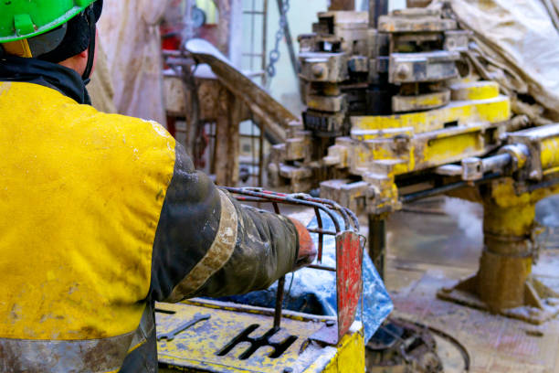 Offshore oil rig worker prepare tool and equipment for perforation oil and gas well at wellhead platform. Making up a drill pipe connection. A view for drill pipe connection from between the stands. Offshore oil rig worker prepare tool and equipment for perforation oil and gas well at wellhead platform. Making up a drill pipe connection. A view for drill pipe connection from between the stands precious metal ira custodians stock pictures, royalty-free photos & images