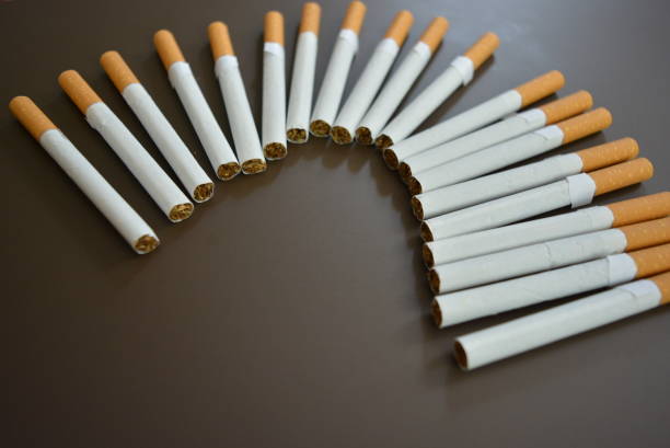 istock New decomposed many cigarettes on a brown matte background. 1146039338