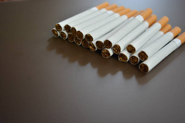 istock New decomposed many cigarettes on a brown matte background. 1146039377