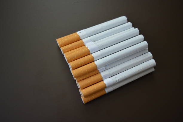 istock New decomposed many cigarettes on a brown matte background. 1146039404