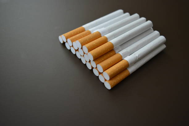 istock New decomposed many cigarettes on a brown matte background. 1146039407