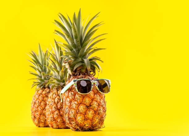 istock Creative pineapple looking up with sunglasses and shell isolated on yellow background, summer vacation beach idea design pattern, copy space close up 1146040868