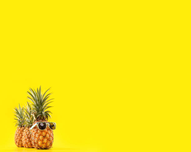 istock Creative pineapple looking up with sunglasses and shell isolated on yellow background, summer vacation beach idea design pattern, copy space close up 1146041019
