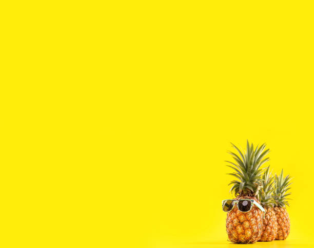 istock Creative pineapple looking up with sunglasses and shell isolated on yellow background, summer vacation beach idea design pattern, copy space close up 1146041282