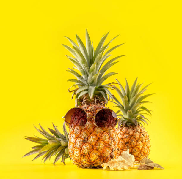 istock Creative pineapple looking up with sunglasses and shell isolated on yellow background, summer vacation beach idea design pattern, copy space close up 1146042028