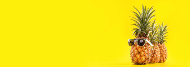 istock Creative pineapple looking up with sunglasses and shell isolated on yellow background, summer vacation beach idea design pattern, copy space close up 1146042143