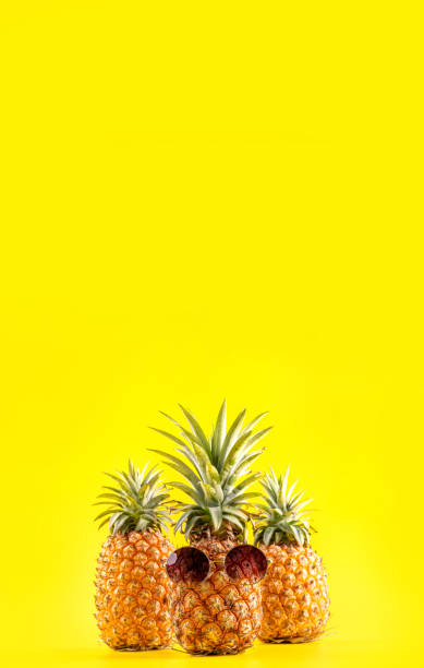 istock Creative pineapple looking up with sunglasses and shell isolated on yellow background, summer vacation beach idea design pattern, copy space close up 1146042181