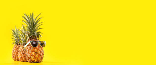 istock Creative pineapple looking up with sunglasses and shell isolated on yellow background, summer vacation beach idea design pattern, copy space close up 1146042508