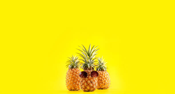 istock Creative pineapple looking up with sunglasses and shell isolated on yellow background, summer vacation beach idea design pattern, copy space close up 1146042544