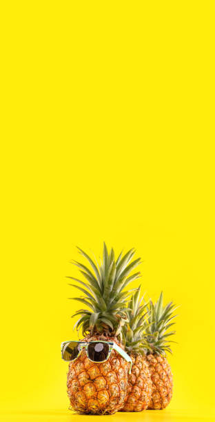 istock Creative pineapple looking up with sunglasses and shell isolated on yellow background, summer vacation beach idea design pattern, copy space close up 1146042621