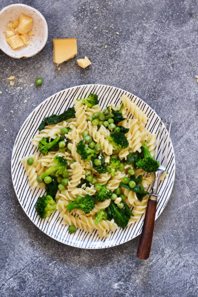 istock Italian pasta with spinach, broccoli and green peas on a concrete background. Dinner time. Top view. 1146044387