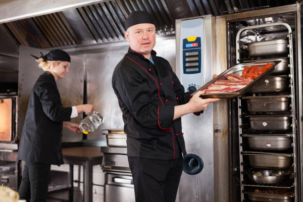 istock Chef holding baking tray with raw meat products 1146049409