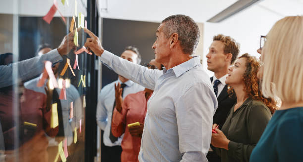 istock Diverse businesspeople brainstorming together with sticky notes in an office 1146050765