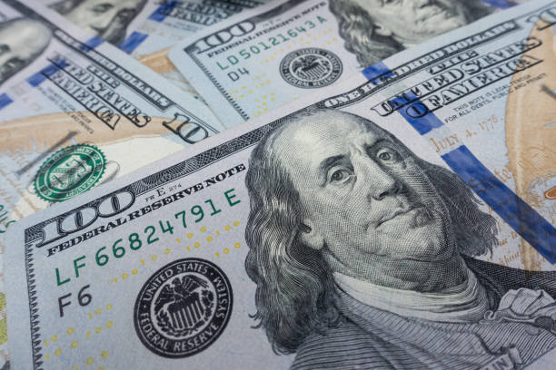 istock $100 bills isolated close-up. Selective focus. 1146051319