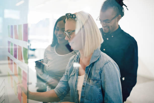 istock Smiling young colleagues brainstorming together with sticky notes at work 1146051373