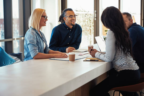 istock Diverse young businesspeople laughing while having a meeting together 1146051556