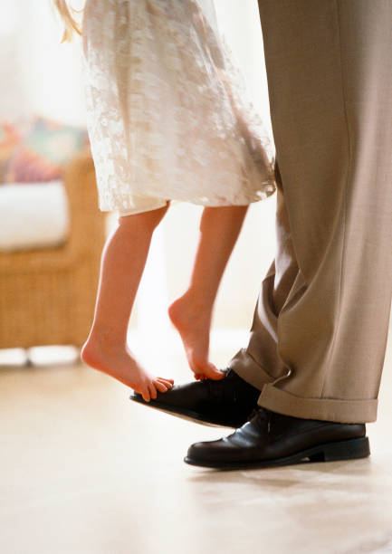 istock girl standing on dads feet 1146054692