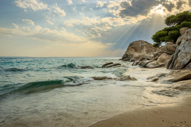 istock Dramatic, colorful sky and rocky edge on a wavy Koviou beach in Greece 1146055890