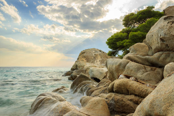 istock Dramatic, colorful sky and rocky edge on a wavy Koviou beach in Greece 1146055931