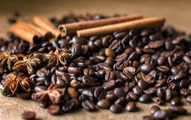istock Roasted coffee beans in bulk on a table with cinnamon and star anise. . Dark still life - Image 1146056066