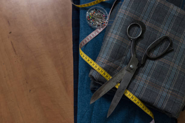 istock Old, vintage shears laying on top of folded wool textile. Top down view of tailor's work table. 1146058402